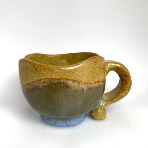 Taza borde curvo. Interior borde y asa amarillo mono. Exterior azul moteado